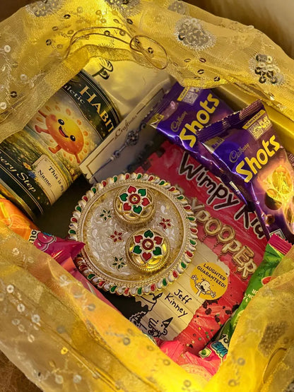 Diary of a Wimpy Kid book with chocolates, decorative Roli Chawal set, and festive gifts inside the Book Lover Rakhi Hamper.