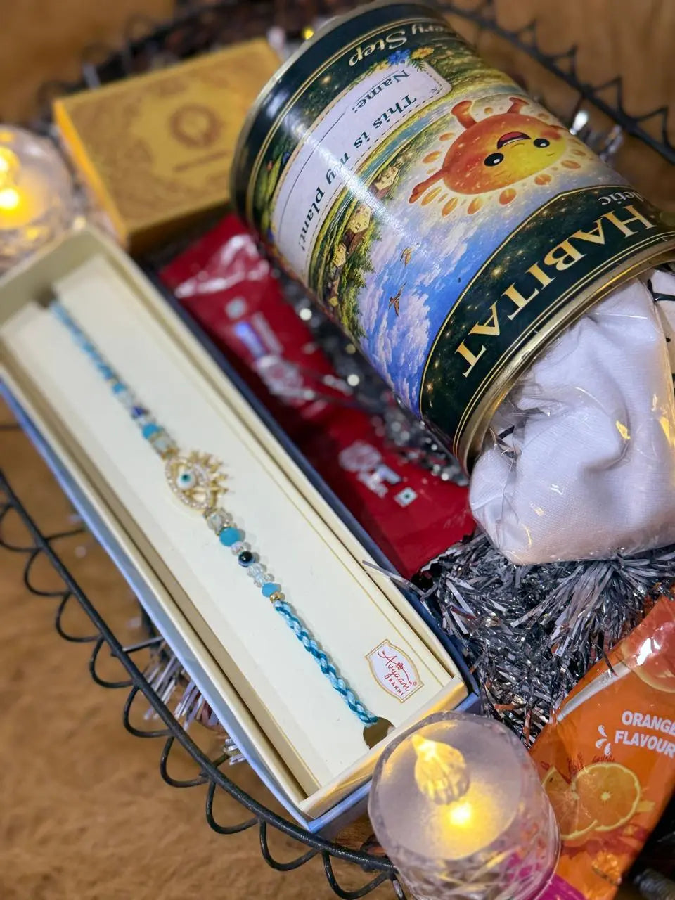 Close-up of the Classic Rakhi Gift Hamper with Evil Eye Crown Rakhi, Sun Activated Kids T-Shirt, KitKat chocolates, and festive essentials.
