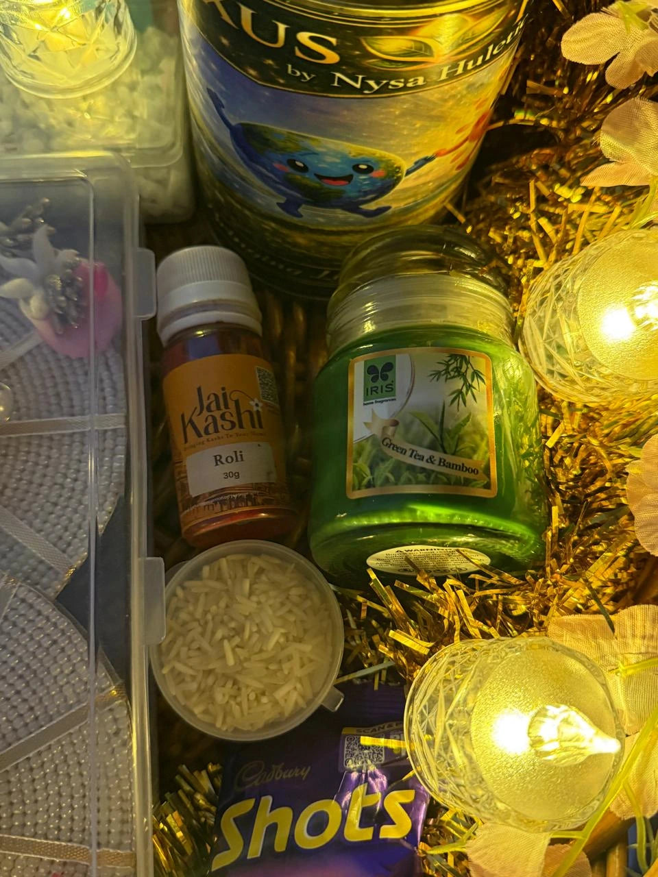 Festive Raksha Bandhan hamper with diya, chocolates, roli, rice, and decorative gifts.