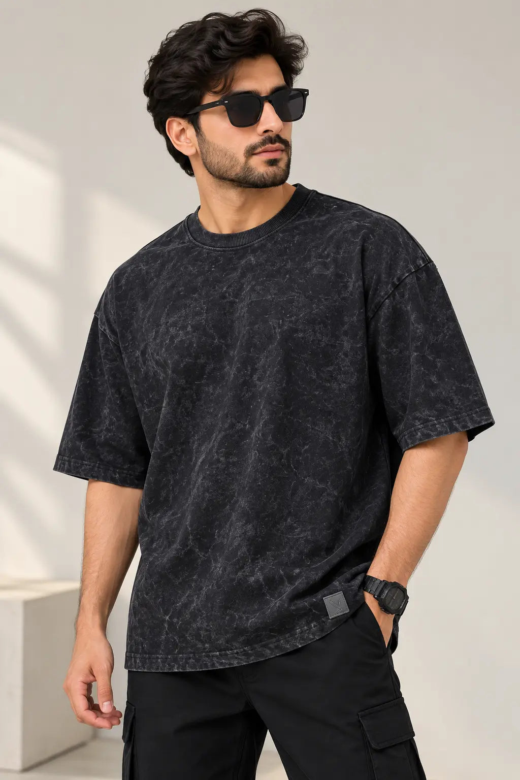 Men's washed black acid wash oversized t-shirt with drop shoulder fit, styled with black cargo pants