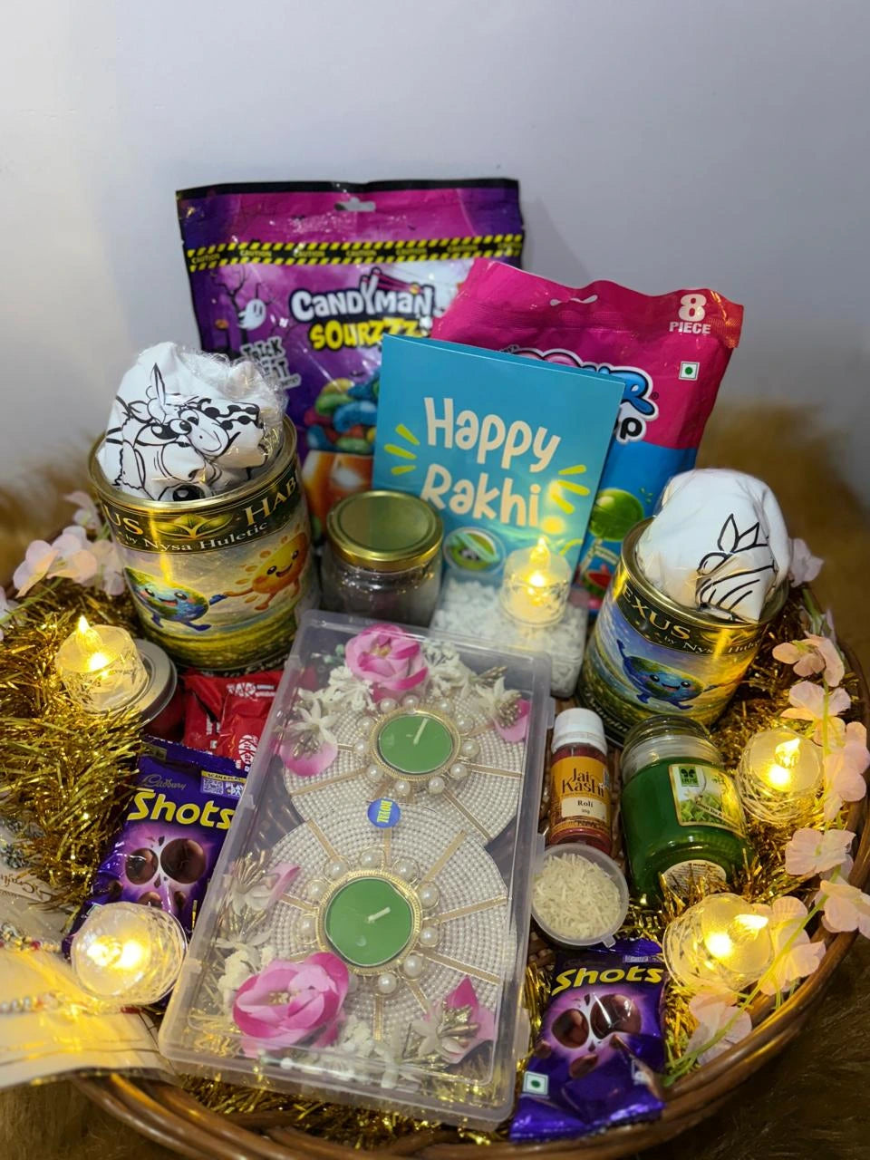 Complete Raksha Bandhan gift basket with Sun Activated T-Shirts, candies, chocolates, Rakhis, diyas, and festive decorations.